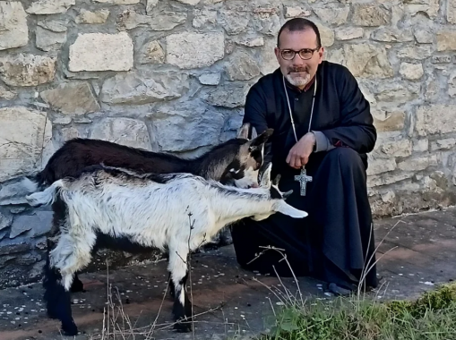 Uno dei monaci con due delle caprette ospiti del rifugio